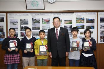 小学生の部、受賞者5名が盾を持って市長と並んで写っている写真