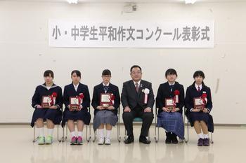 中学生の部受章者5名が盾を持って椅子に座っており、市長と並んで写っている写真