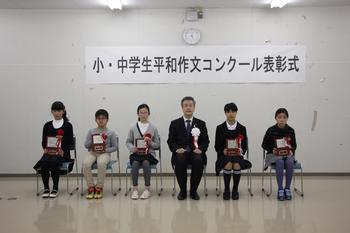 小学生の部受章者5名が盾を持って椅子に座っており、市長と並んで写っている写真