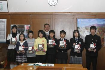 小・中学生平和作文コンクール（平成22年度）入賞者が盾を持って並んで写っている写真