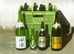 一升瓶、ビールびん、日本酒の瓶等がボックスコンテナの前に置かれている写真