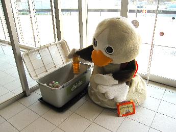 使用済み食用油の入ったペットボトルを入れるパタ崎さん