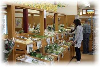 道の駅三本木「やまなみ」できれいに陳列されている野菜を見ている買い物客の写真