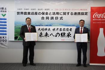 コカ･コーラボトラーズジャパン株式会社の代表者と大崎市長が協定書をもって立っている写真