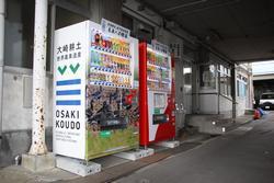 大崎市役所西庁舎前に設置された世界農業遺産ロゴマークの自動販売機と赤い色の自動販売機の写真
