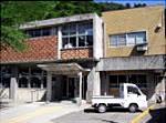 二階建ての大崎市鳴子総合支所の建物と駐車場に停まっている1台の軽トラックの写真
