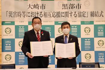 協定書を取り交わす、右：大野黒部市長と左：伊藤大崎市長の写真