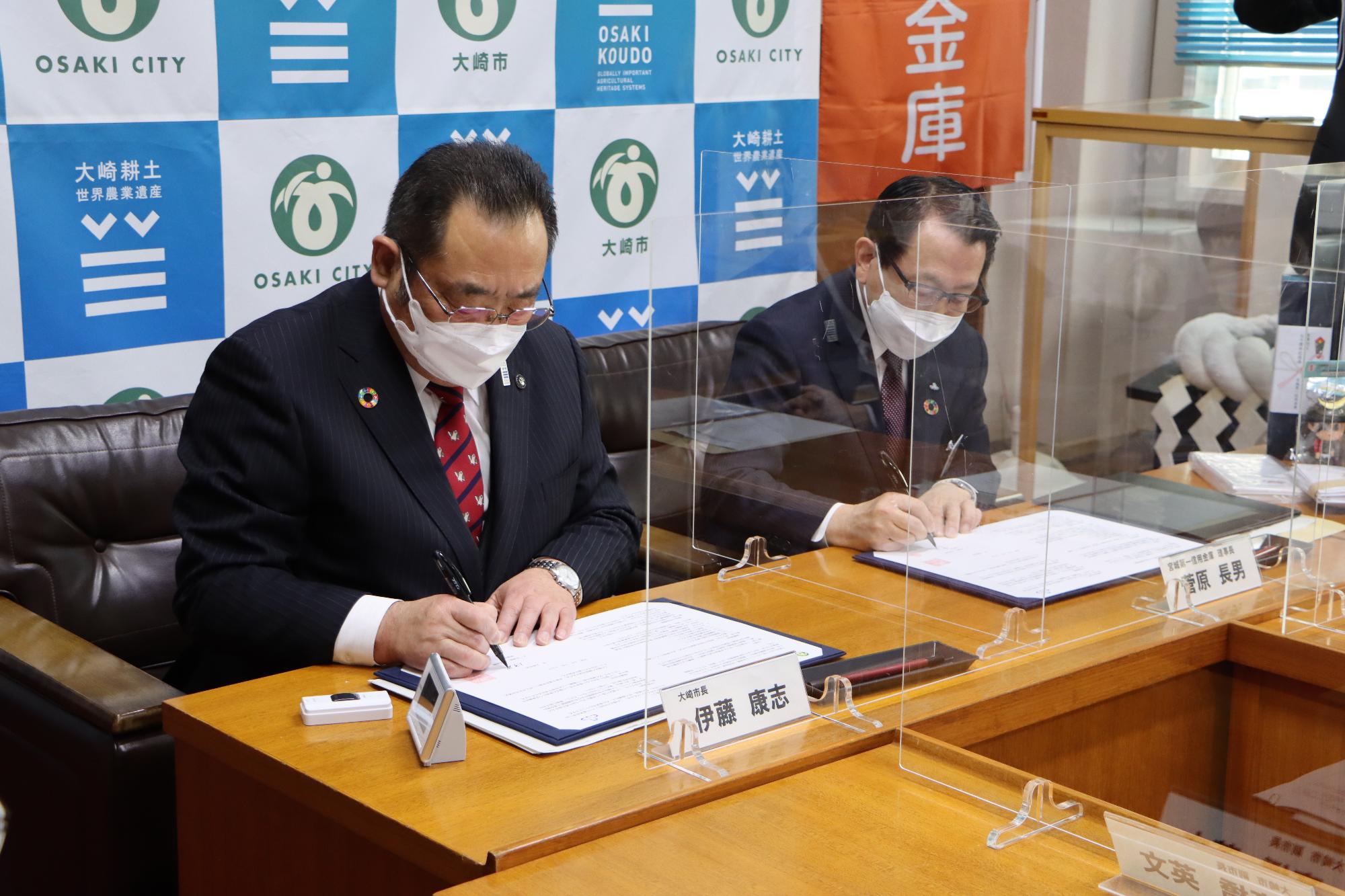 協定書に署名をする宮城第一信用金庫の菅原理事長と大崎市長