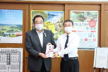 メガネの相沢古川中里店の阿部光彦店長と市長が目録を持って並んで写っている写真