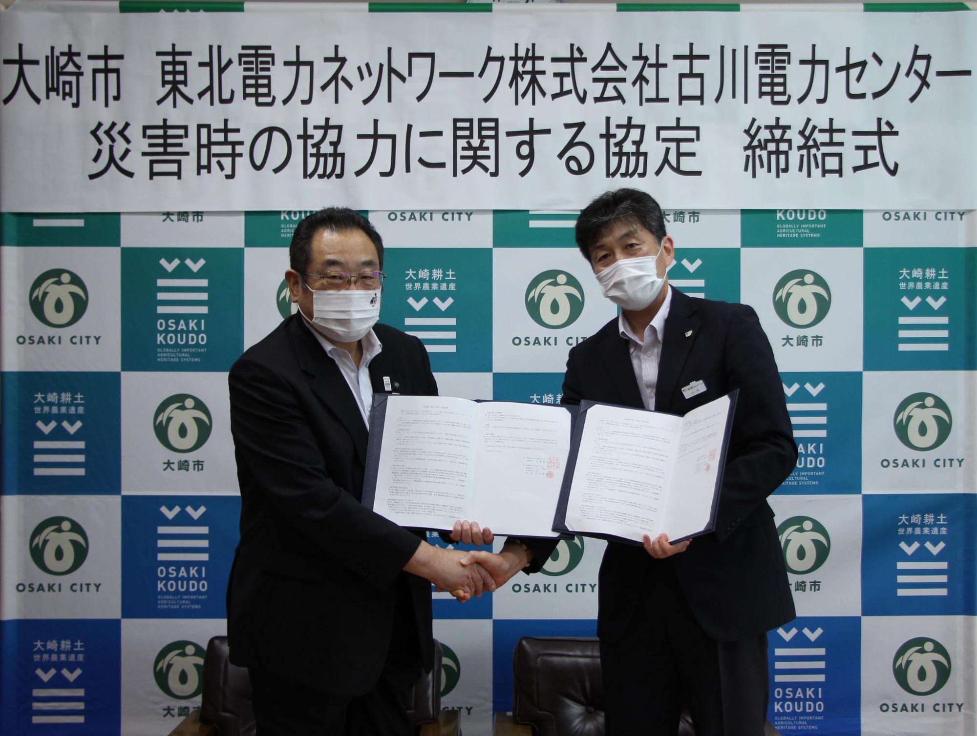 東北電力ネットワーク株式会社古川電力センターの代表の男性と市長が協定書を持って並んで立っている写真