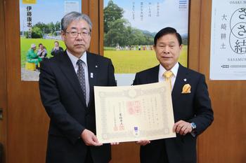 スーツを着た男性2名が賞状を持って写っている紺綬褒章贈呈の様子の写真