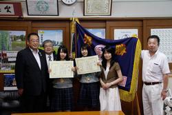 報告に訪れた佐々木華歩さん（左から3人目）と遠山真央さん（右から3人目）の後ろに優勝旗を飾り市長に報告をした時の写真