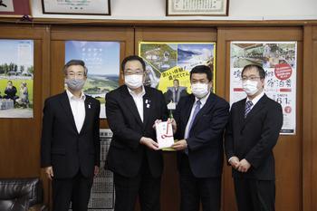 市長と株式会社ホンダセントラルの方が寄附金を持ち、4人で記念写真