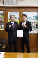 ISAO選手から頂いた色紙を高橋副市長が持って、ISAO選手とガッツポースをして写っている写真