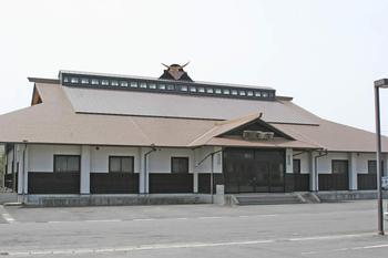 オレンジの屋根にソーラーパネルが設置された、岩出山武道館の外観写真