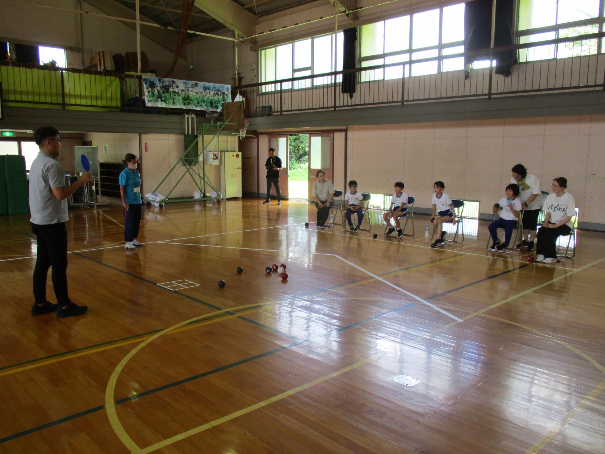椅子に座って投球している写真
