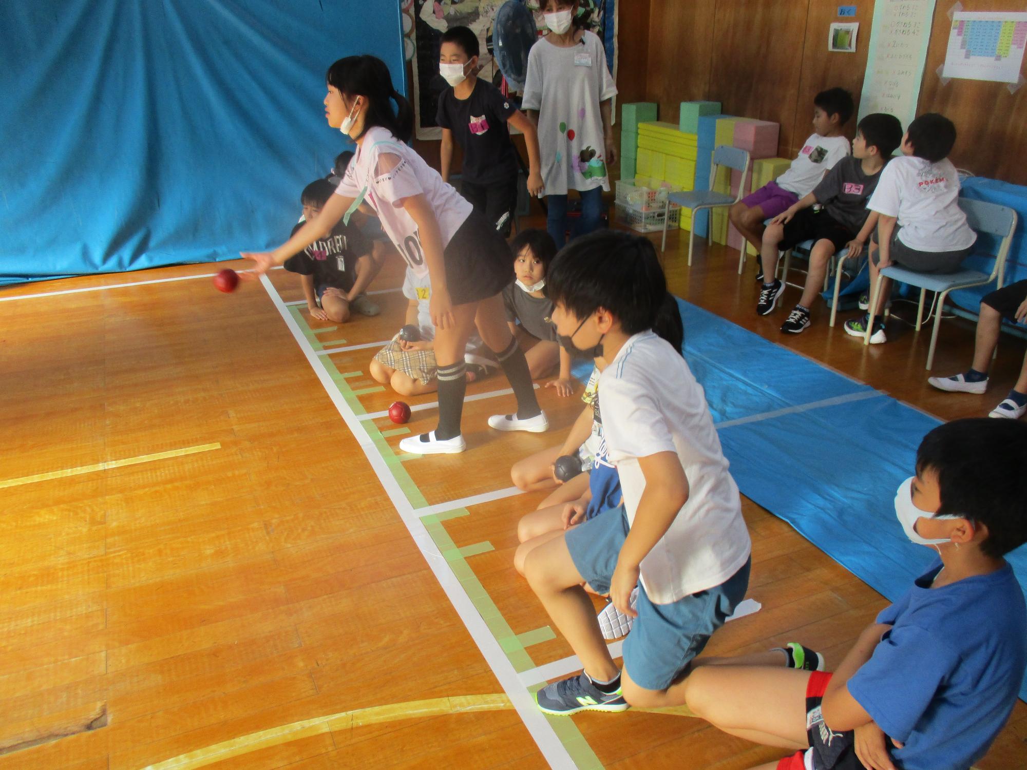 大宮児童センターボッチャ大会で児童が横一列に並んでボールを投げている写真