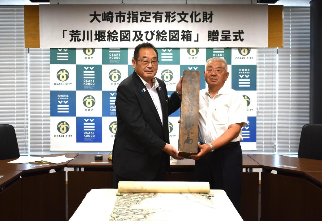 荒川堰絵図および絵図箱を市長に贈呈している写真