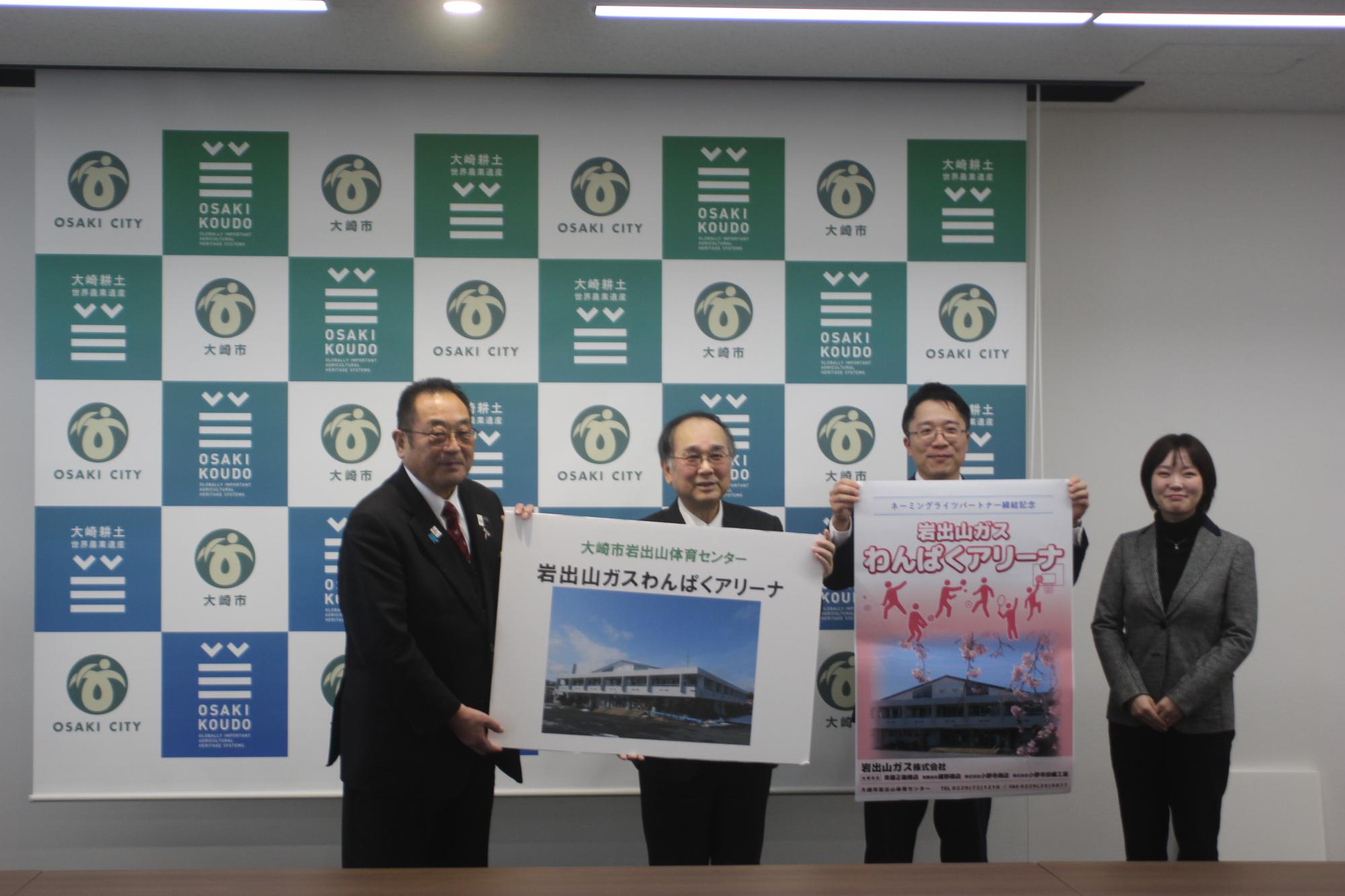 大崎市長と岩出山ガス株式会社の代表者と社員が施設のパネルを持って写真撮影