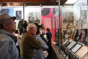 展示されているフランク永井の賞状や賞牌を眺めている来館者の写真