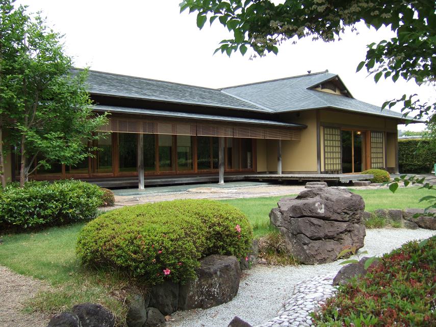 芝生やつつじなど綺麗な日本庭園と祥雲閣の外観の写真